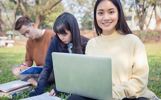 在草地上学习的学生